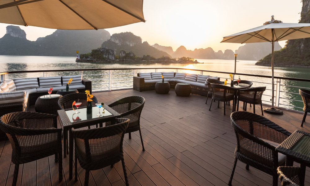 Overview of Jade Sails sundeck during dusk with many sofas.