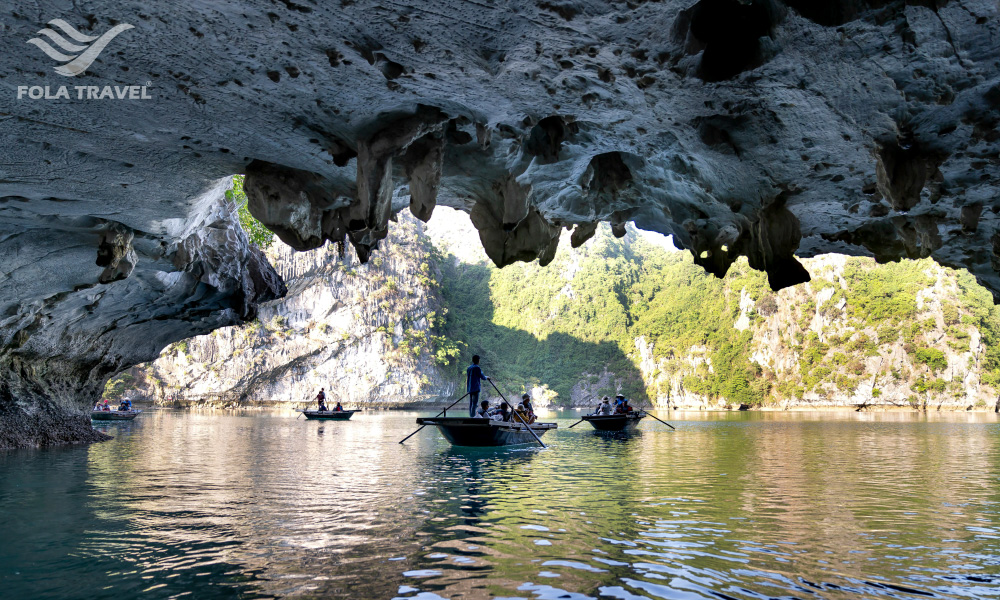 Three bamboo boats sailing through Sang Toi Cave.