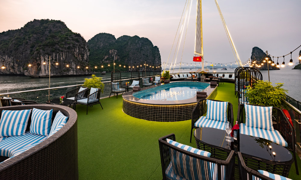 A sundeck with a big jacuzzi in the middle and Halong Bay islands outside.