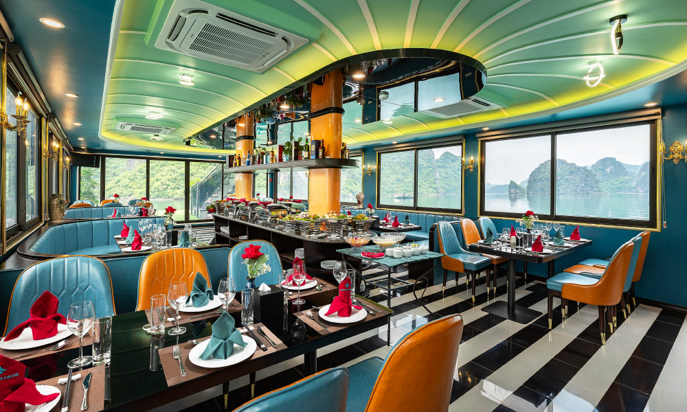 A luxury restaurant with green floors and turquois chairs, facing big windows.