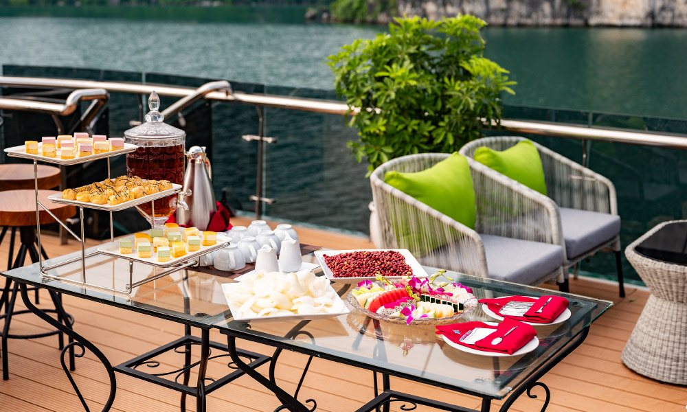 A table full of cakes and sweet treats on a cruise deck.