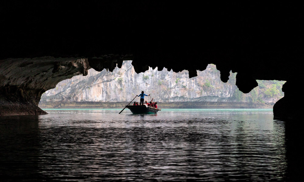 The Luon Cave in Lan Ha Bay, Vietnam with a bamboo boat going through it.