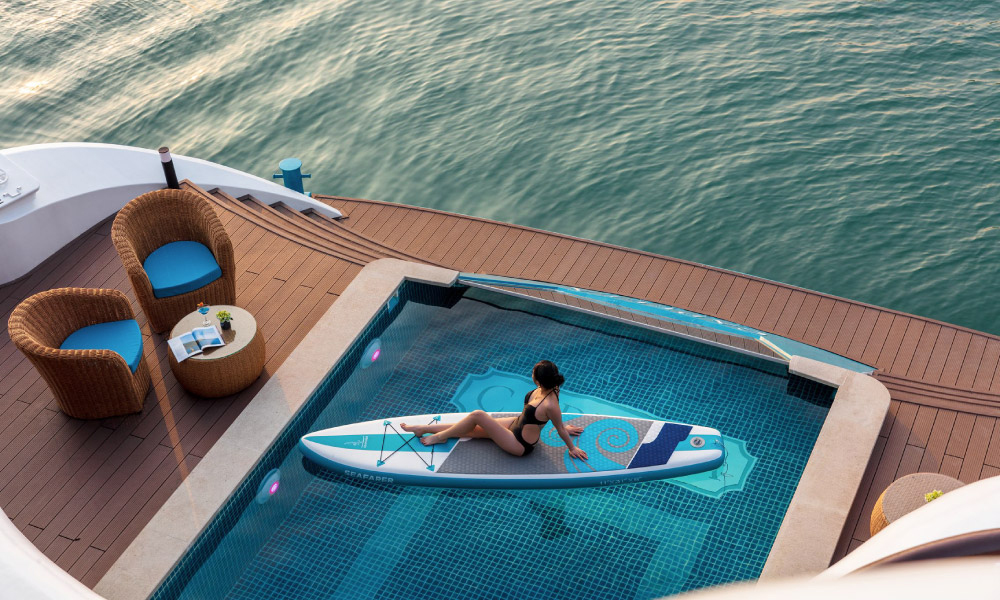 The Capella swimming pool looking from above with a girl sitting on a paddle in the middle.