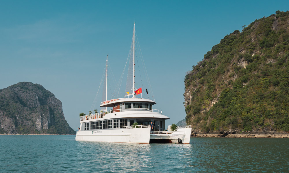 The Cat Ba Catamaran Cruise sailing between two islands,