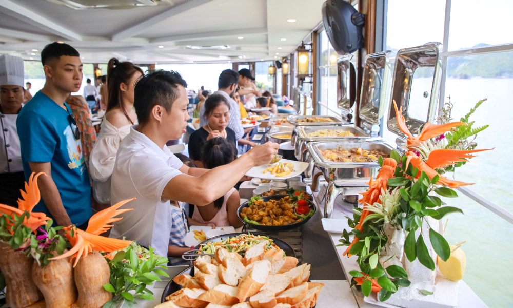 The buffet station on Cat Ba Catamaran cruise with guests taking food.