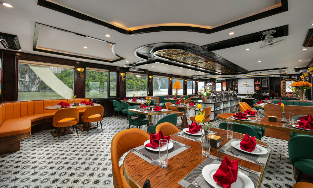 A restaurant with green and orange chairs, big windows with view of Halong Bay outside.