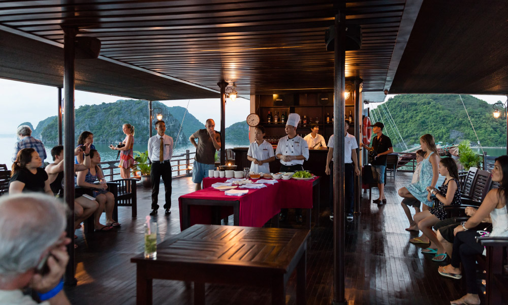 mila cruise guests join cooking lesson on the deck with halong bay in the background