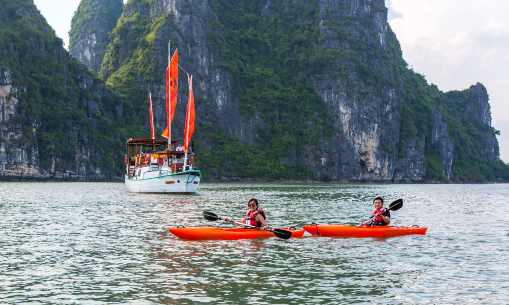 Two kayaks sailing in front of the Emeraude Min Cruise.