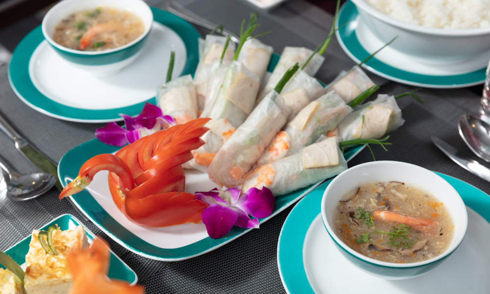 A plate of spring rolls and two sauce bowls.