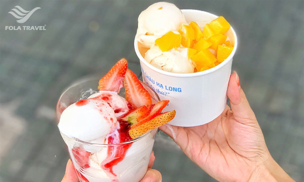 Two cups of Halong Bay yogurt with mango and strawberry toppings.