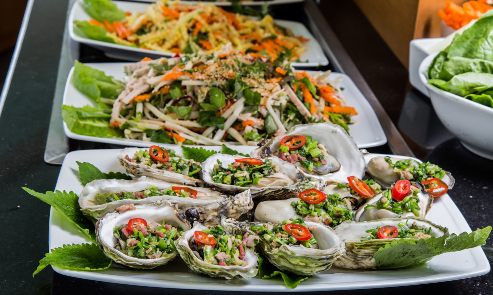 Plate of grilled oysters and onion oil.