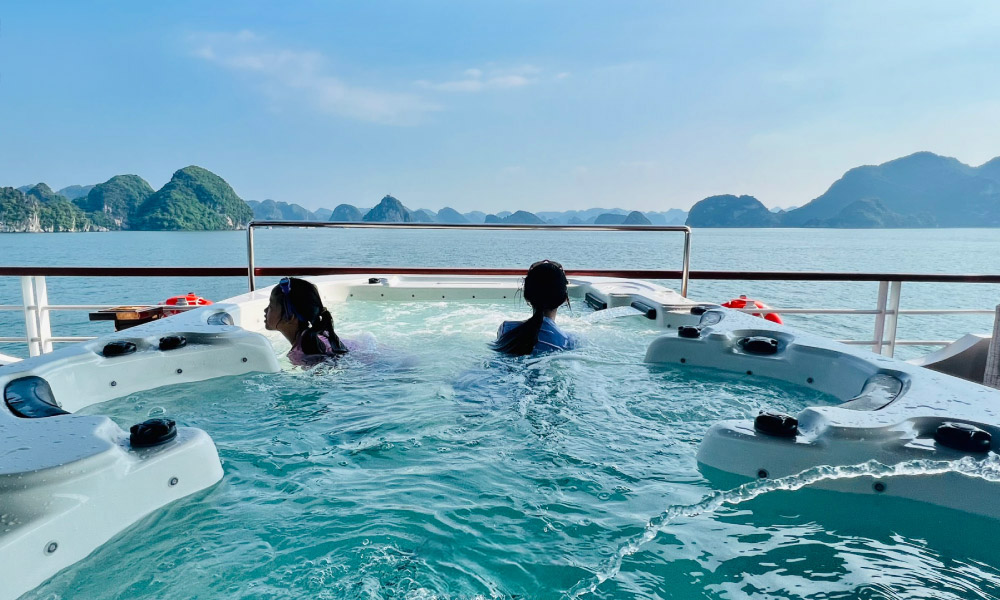 Two guests of Iris Cruise in a jacuzzi with open view of Halong bay.