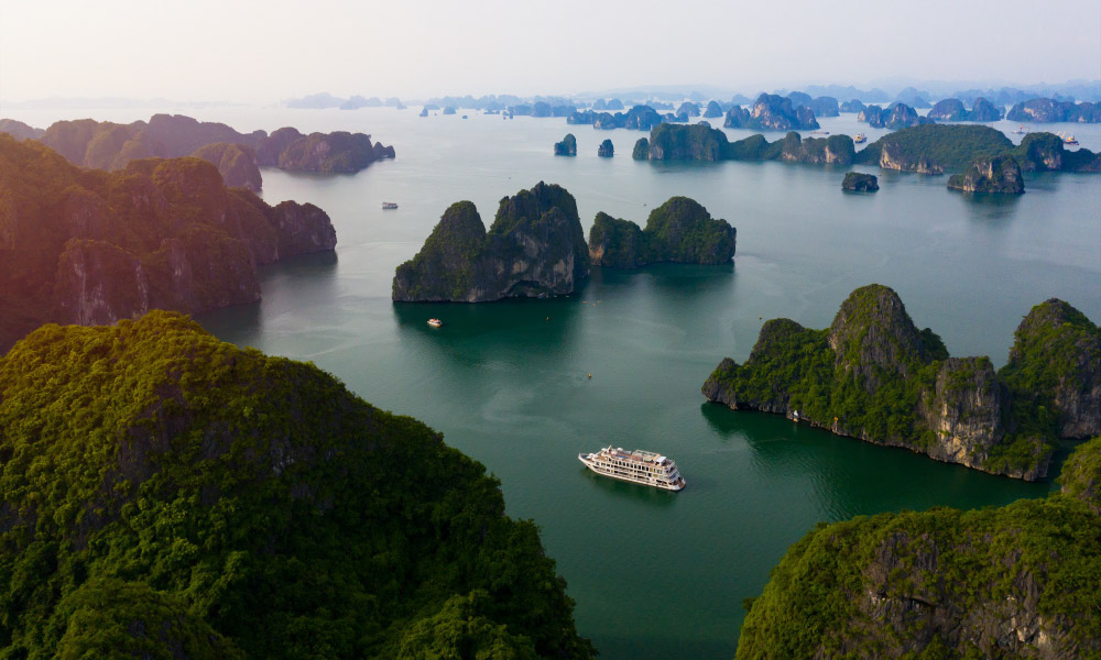 panoramic view of halong bay islands with hermes cruise in the middle