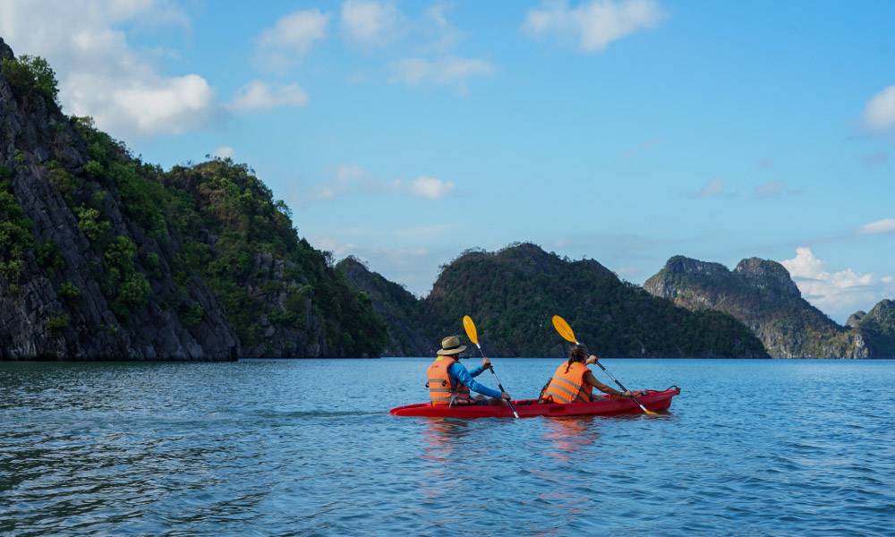 a couple of mon cheri cruises kayaking in the middle of halong bay