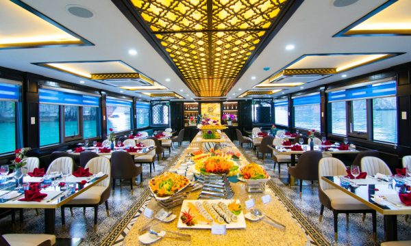 The restaurant on La Casta Cruise with a gold buffet station right in the middle and a gold line on the ceiling, two sides are tables and chairs.