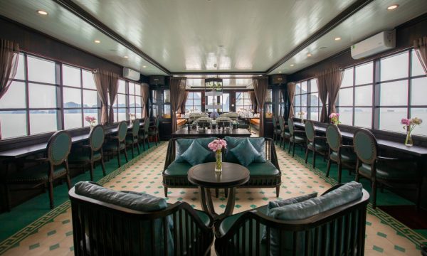 the restaurant on la muse cruise with dark green chairs and wooden table