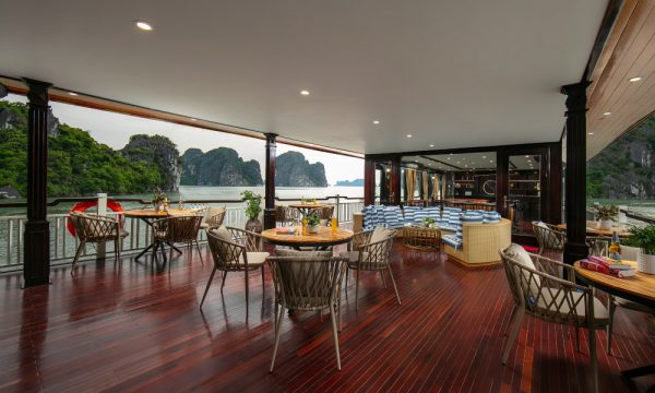 A corner of the bar on La Regian Cruise with wooden chairs and sea-view windows.