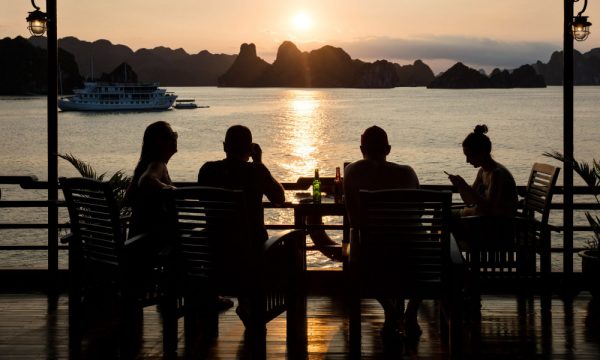 four people sitting on the sundeck watching halong sunset