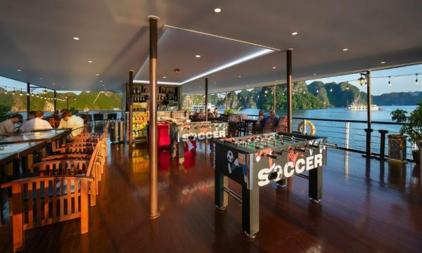 the outdoor sundeck of halong mila lux cruise with tables and a bar