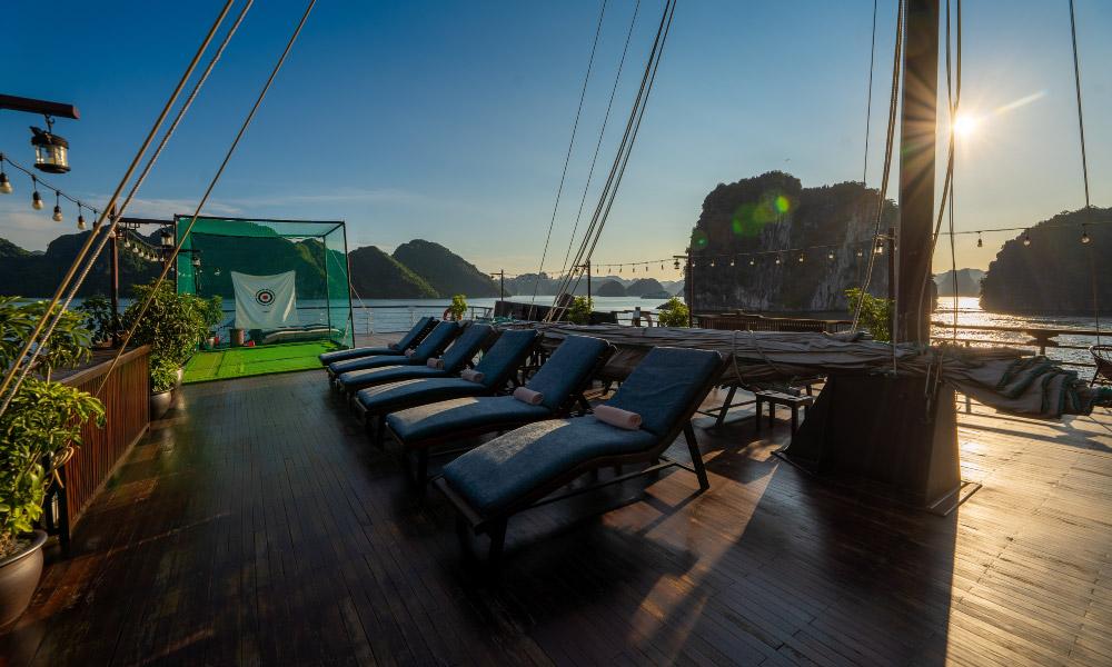 a row of lounge chairs on the cruise deck during sunset