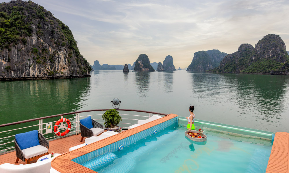 a pool on the sundeck of mon cheri cruise looking out to the halong bay sea and islands