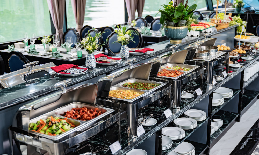 A buffet line with trays of Vietnamese food in a restaurant.