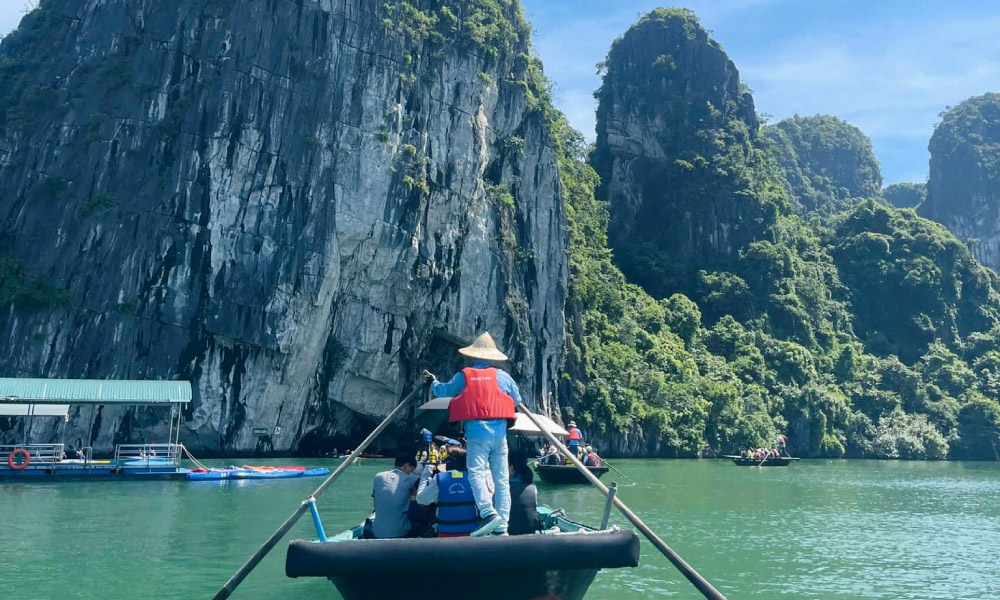 A bamboo boat going in the middle of Halong Bay riding guests of Pamela Cruise.