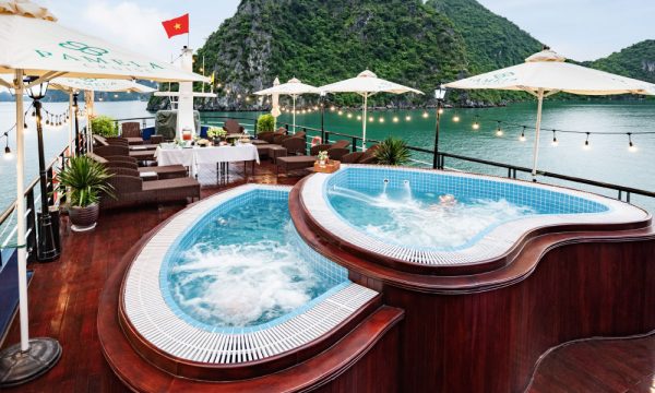 A sundeck with a heart-shaped jacuzzi and may lounge tables.