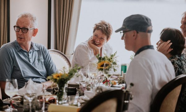 Guests laughing and sitting around a table with many sunflowers.
