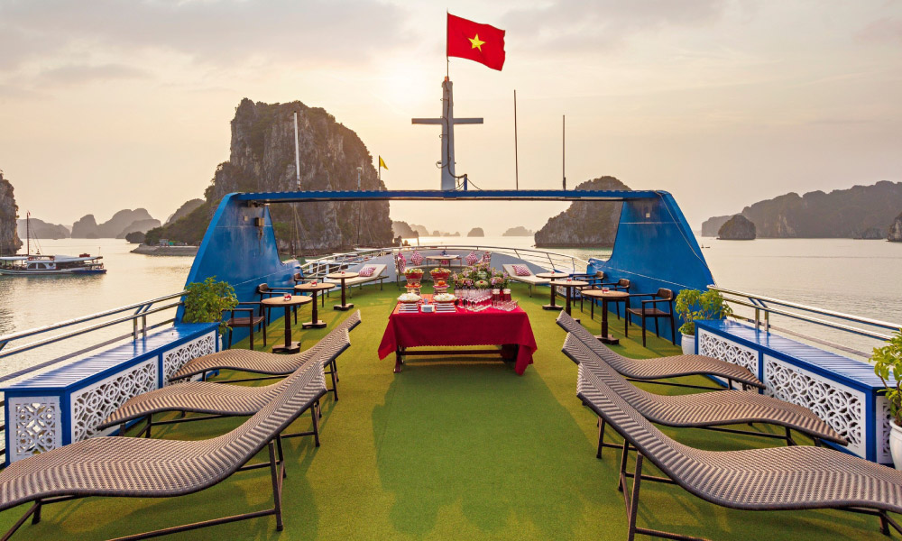 A sundeck with view of Halong Bay islands during dusk.