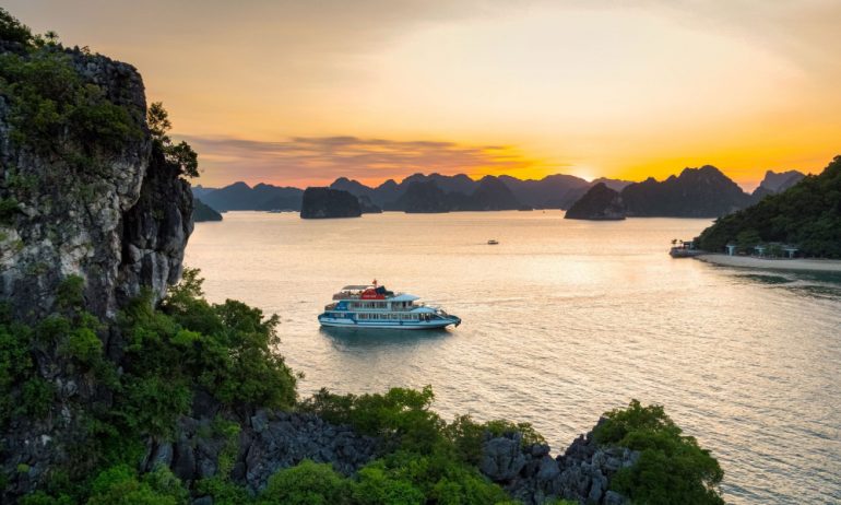 Sunset view in Halong Bay with Cozy Bay Cruise sailing through the islands.