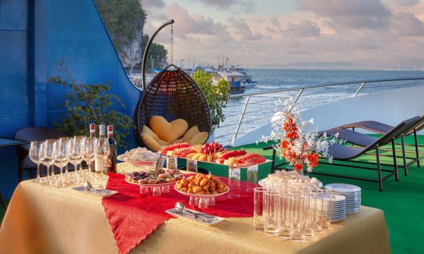 A table full of snacks and drinks with red table cloth.