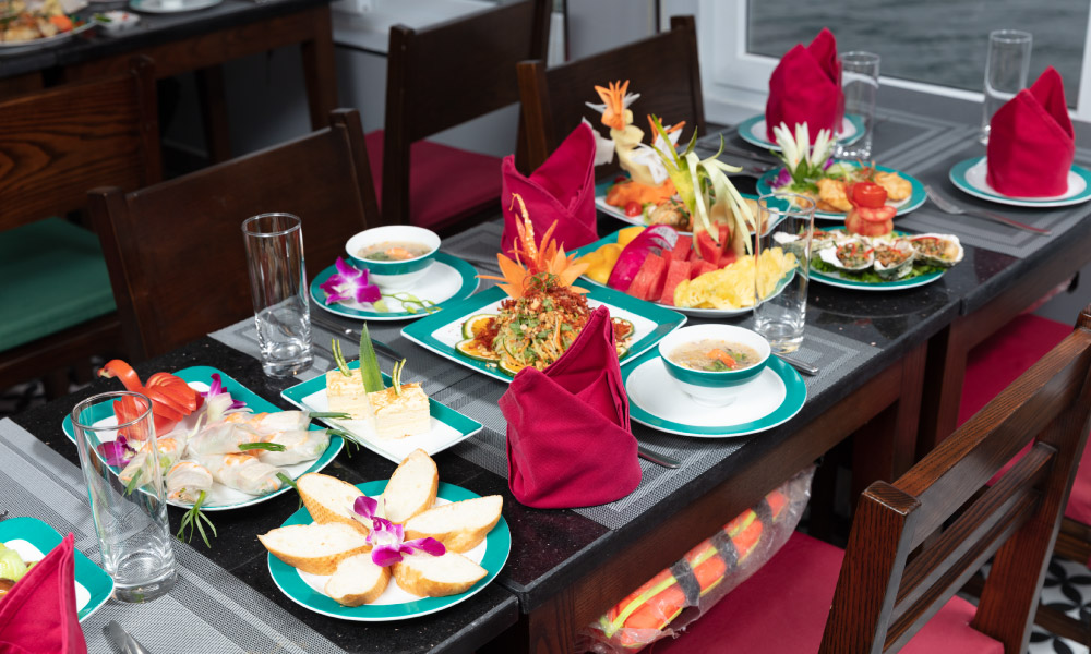 a table with Vietnamese dishes on turquoise plates and red towers