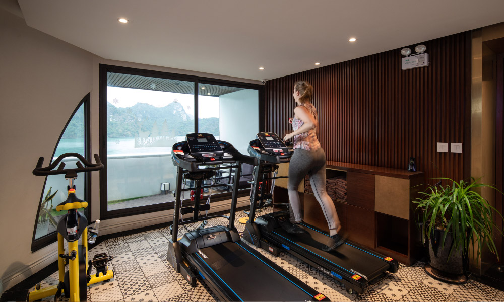 a girl running in a gym room facing a window