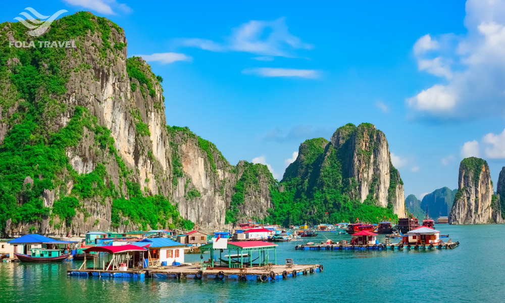 Colorful houses under big islands in Halong Bay.