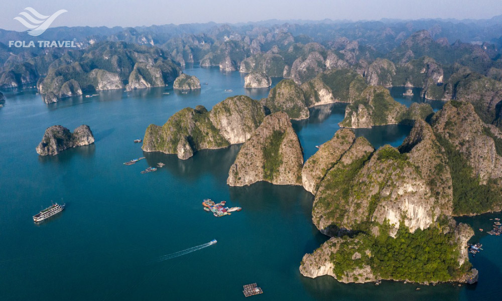 Panoramic view of Lan Ha Bay islands and sea, with small cruises and floating houses.