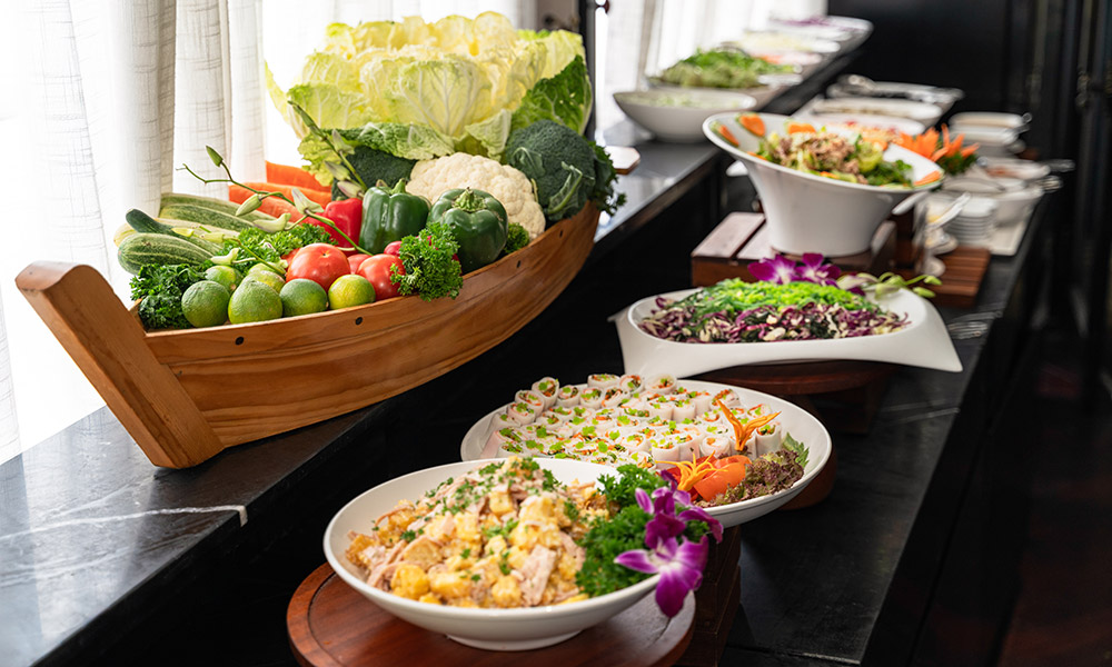 Table with trays of buffet vegetables.