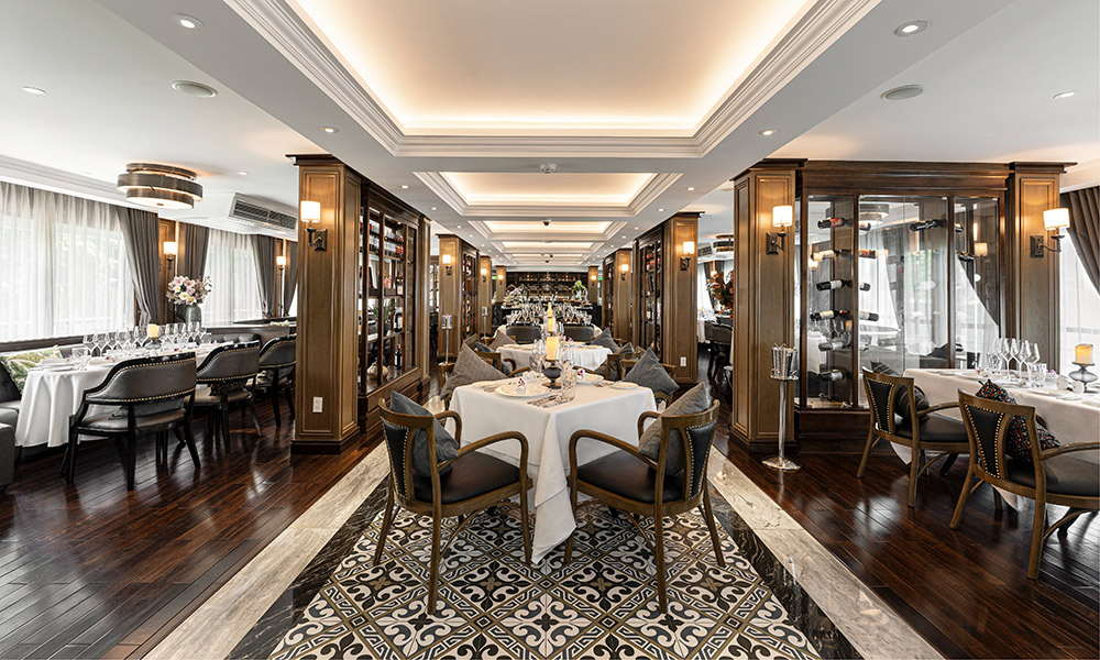 A restaurant with three rows of tables separated by different dividers.