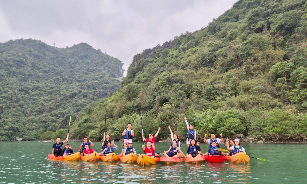 a group of halong visitors do kayaking