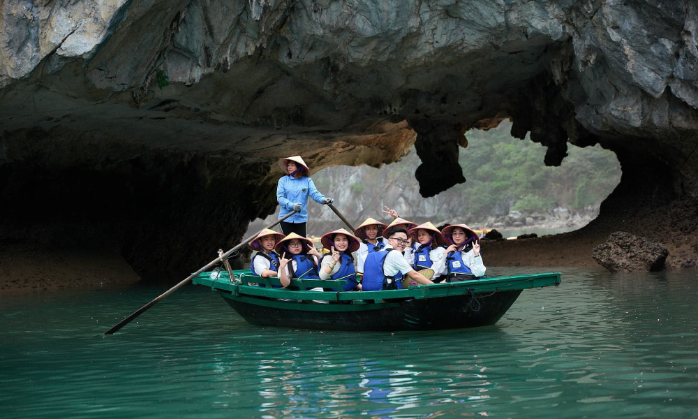 Going through Luon Cave on bamboo boats in Halong Bay