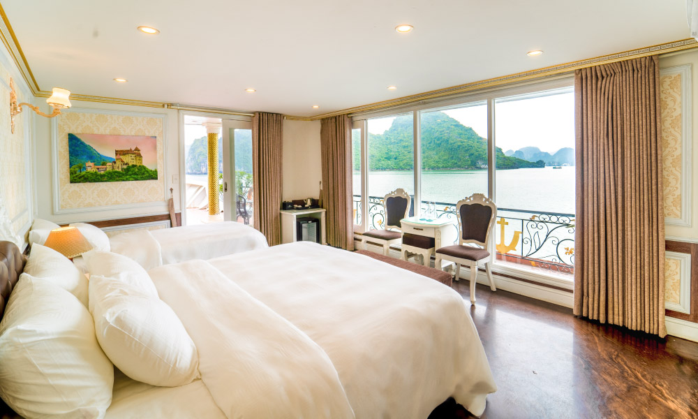 A room with one double and one twin beds, all facing some chairs and a big window where you can see an island outside.