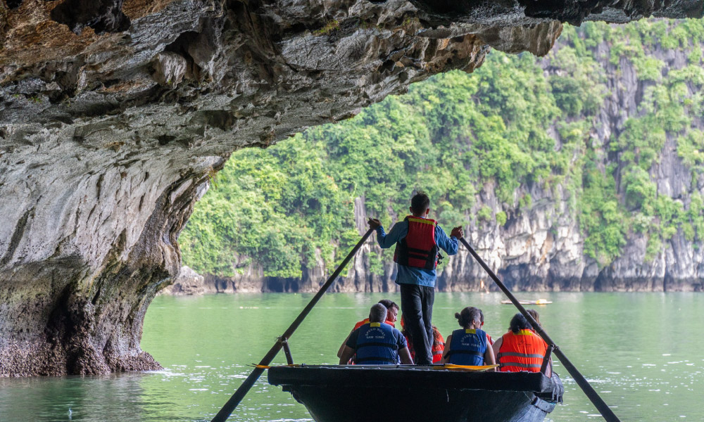 a bamboo boat going through luon cave