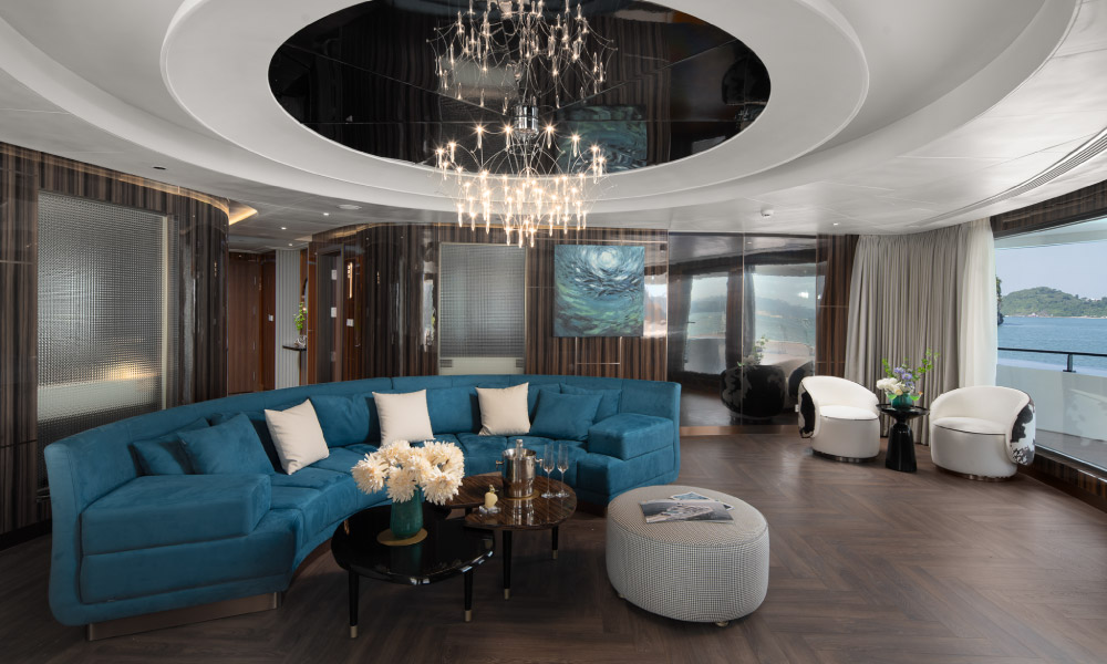 A big room with blue sofa, round ceiling lights, and many chairs around.