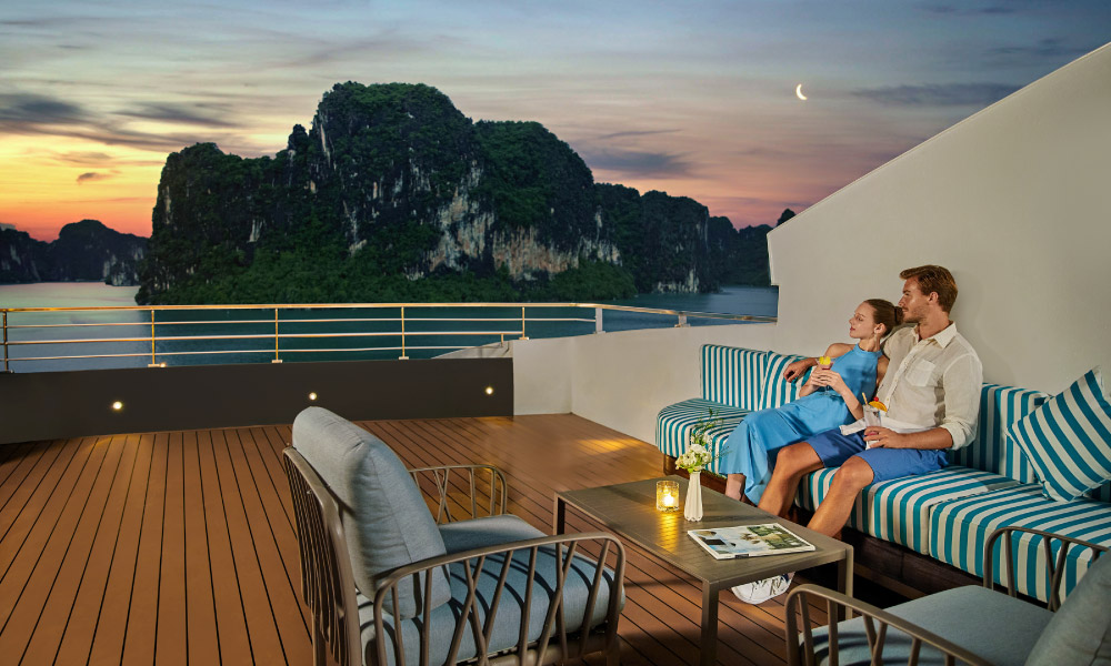 two guests enjoying the night view of halong bay islands