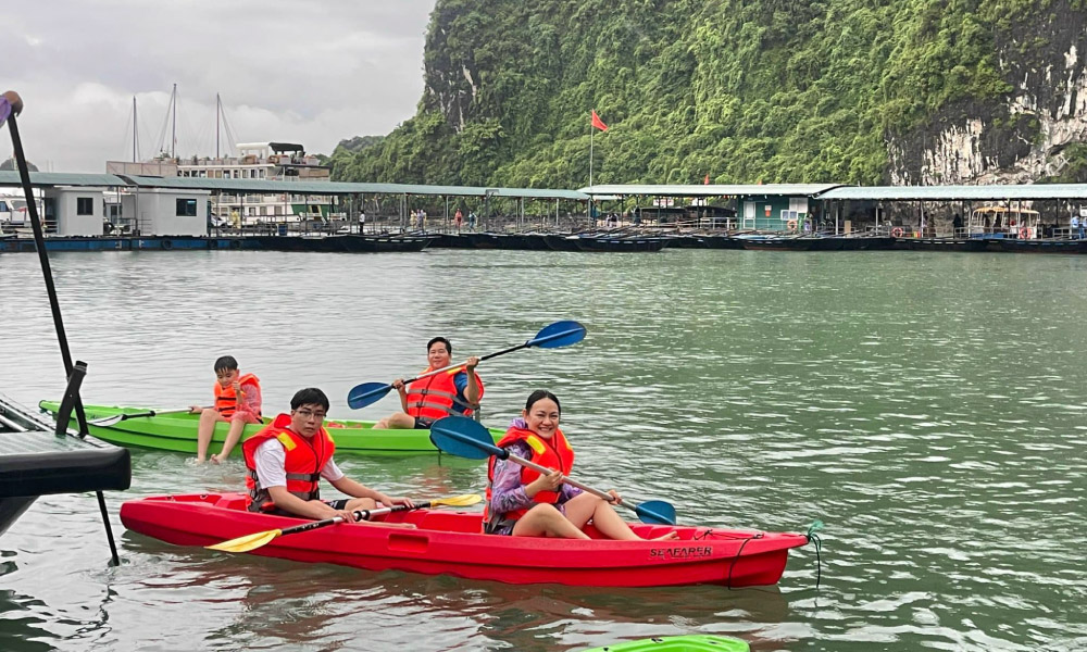 halong visitors on a red and green kayak