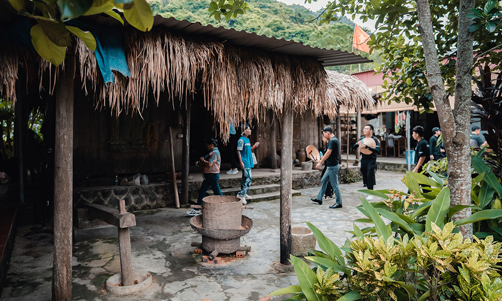 An old house made of bamboo with guests visiting.