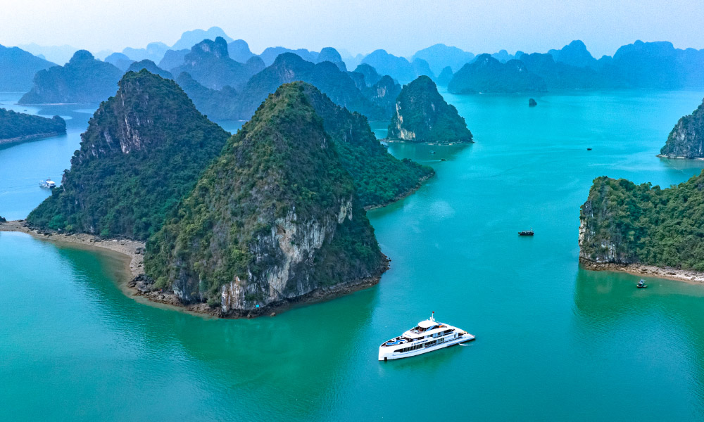 panoramic view of halong bay with symphony day cruise passing by the islands