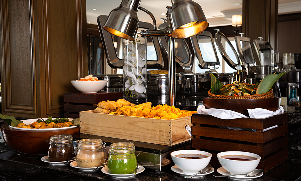 Buffet station with trays of different food and sauces.