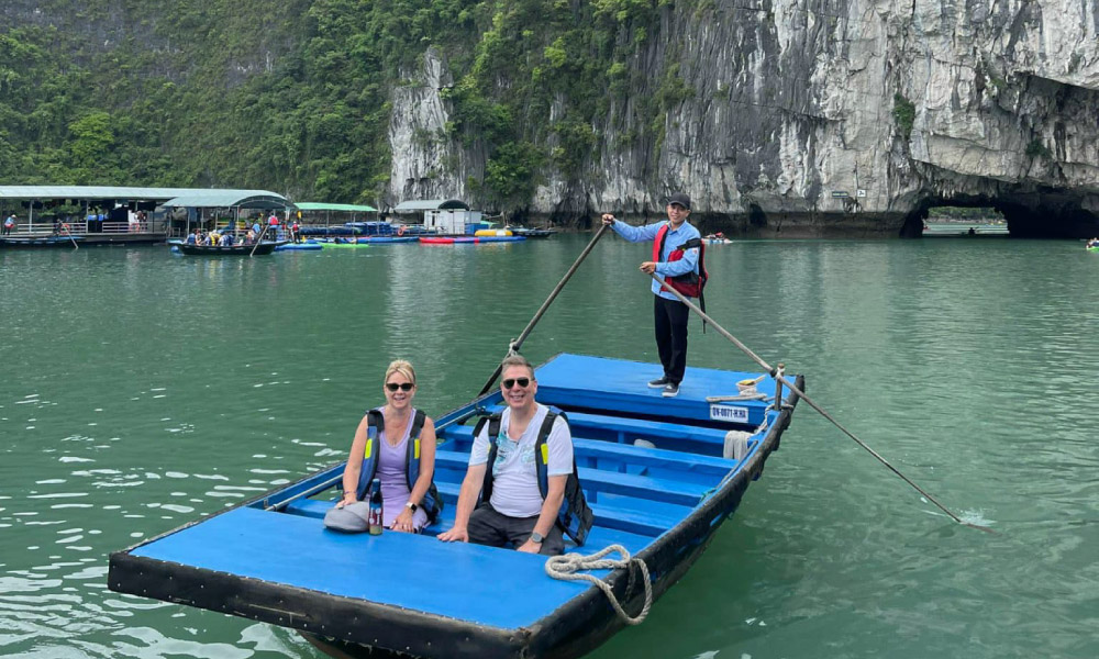 visitors of halong bay on a bamboo boat