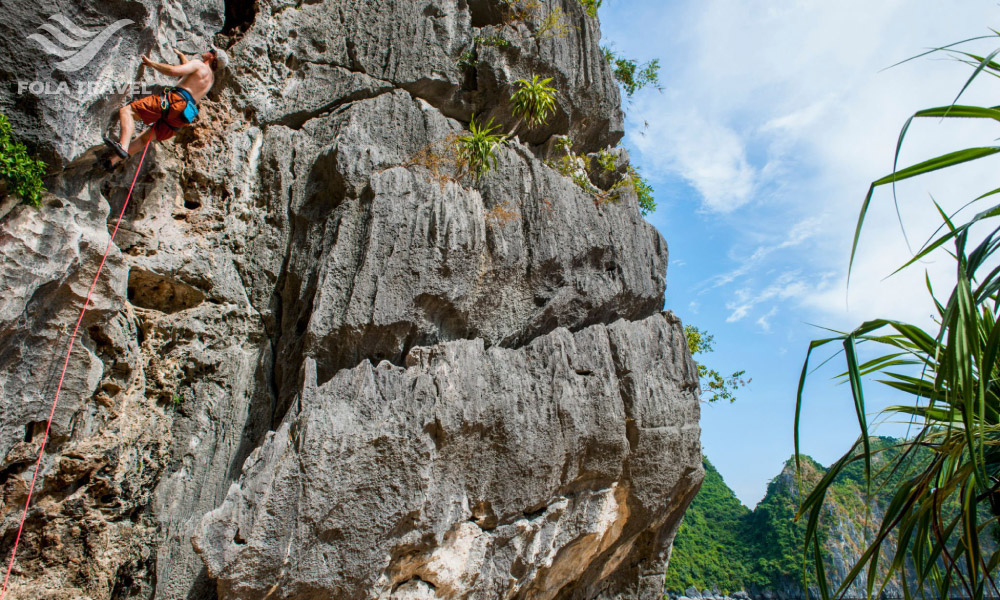 A person climb on a big rock island.